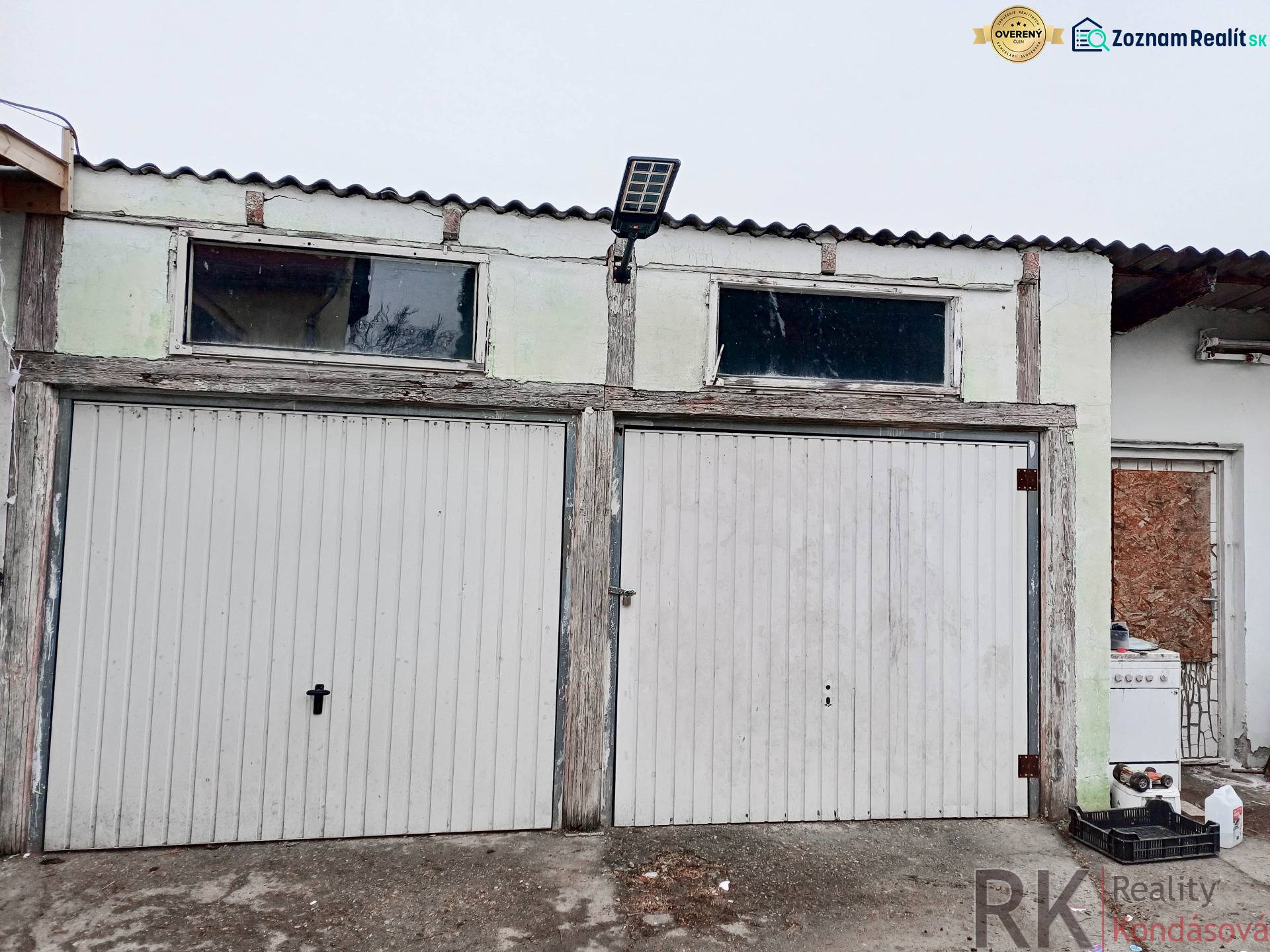 Garáž se dvěma roletovými dveřmi a solárním panelem u rodinného domu ve Vizsoly.