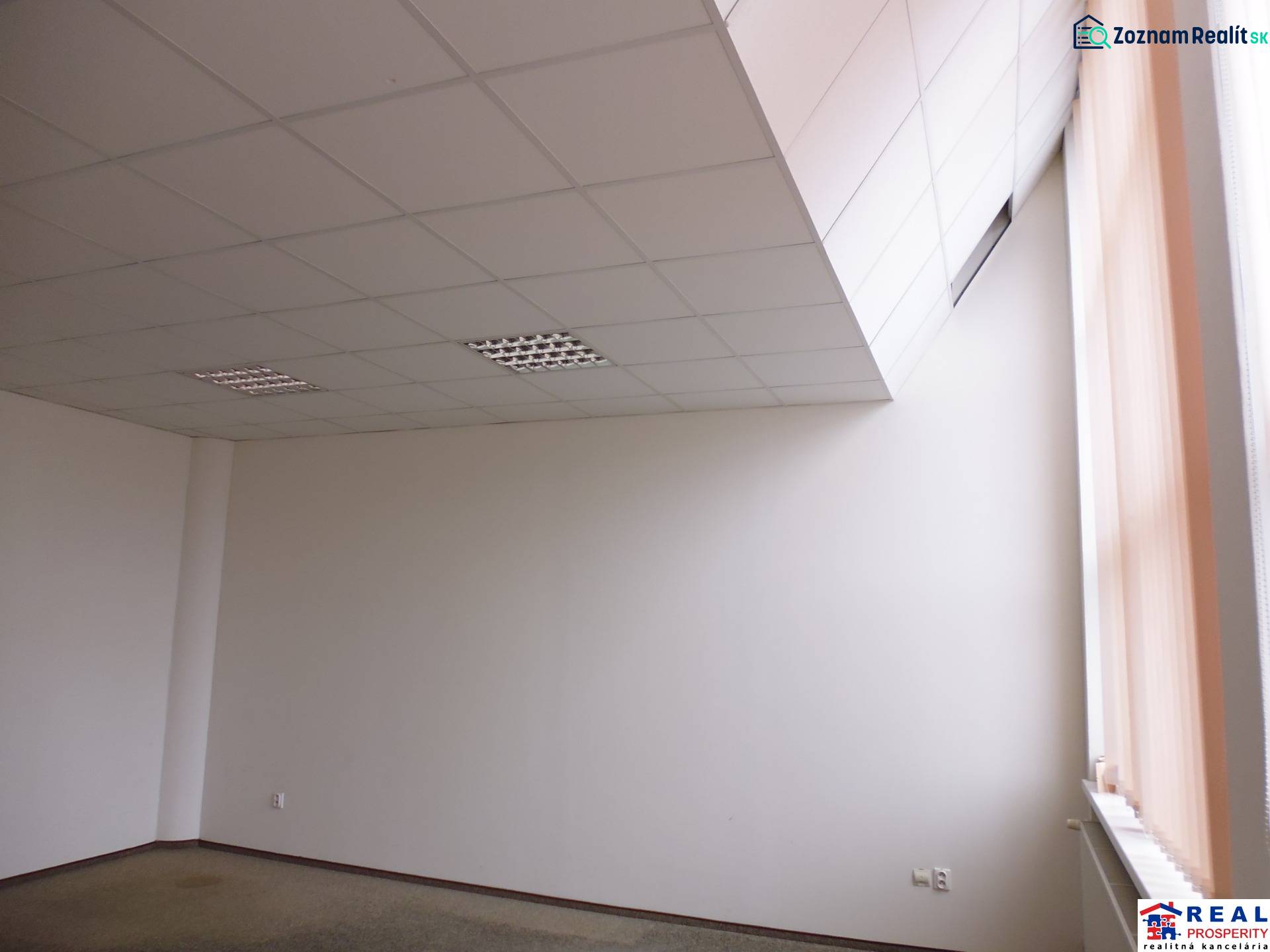 Prostorná kancelář s podlahou s dřevěným dekorem a velkým oknem, vhodná k práci.