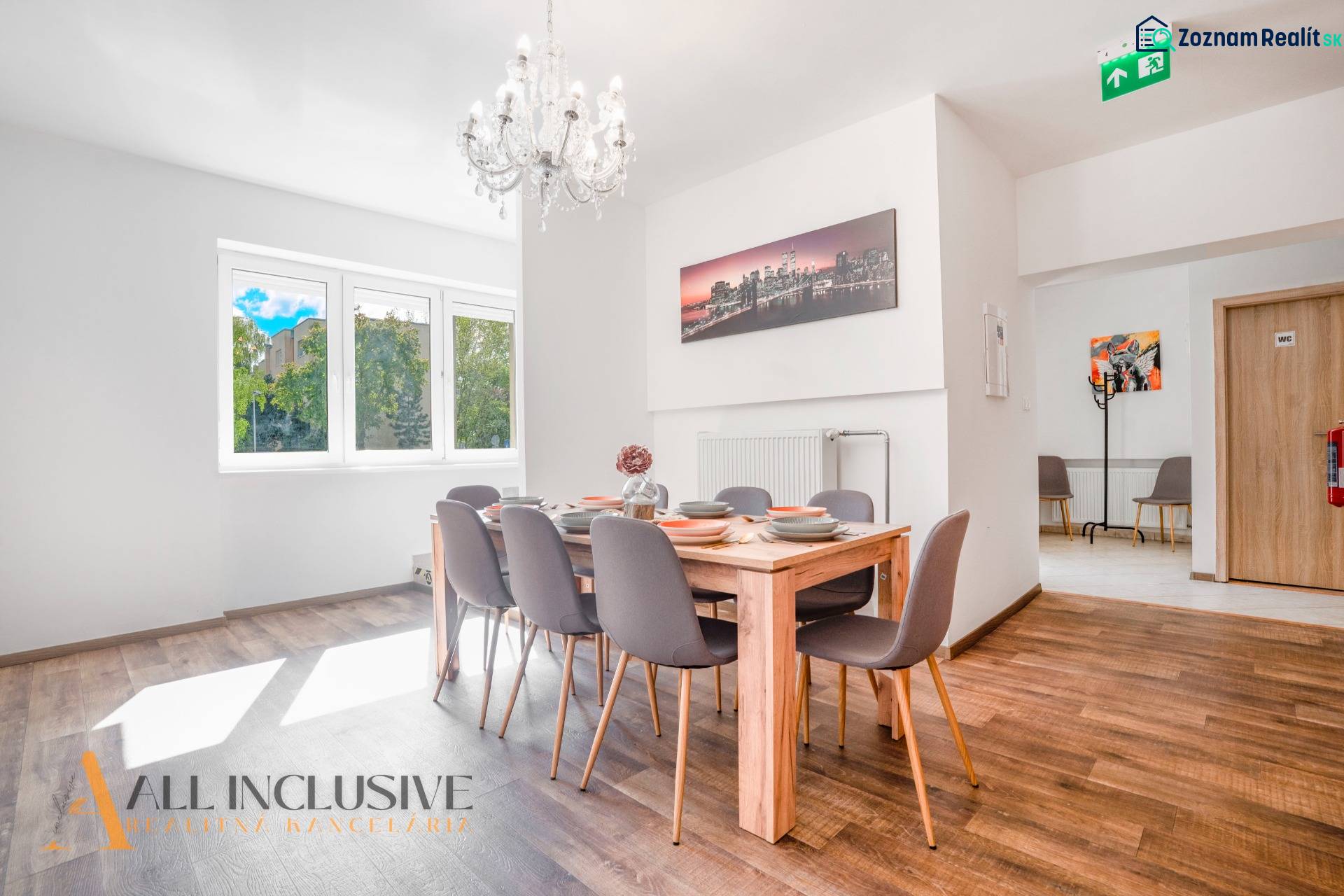 Jídelna s lustrem a podlahou s dřevěným dekorem v budově.