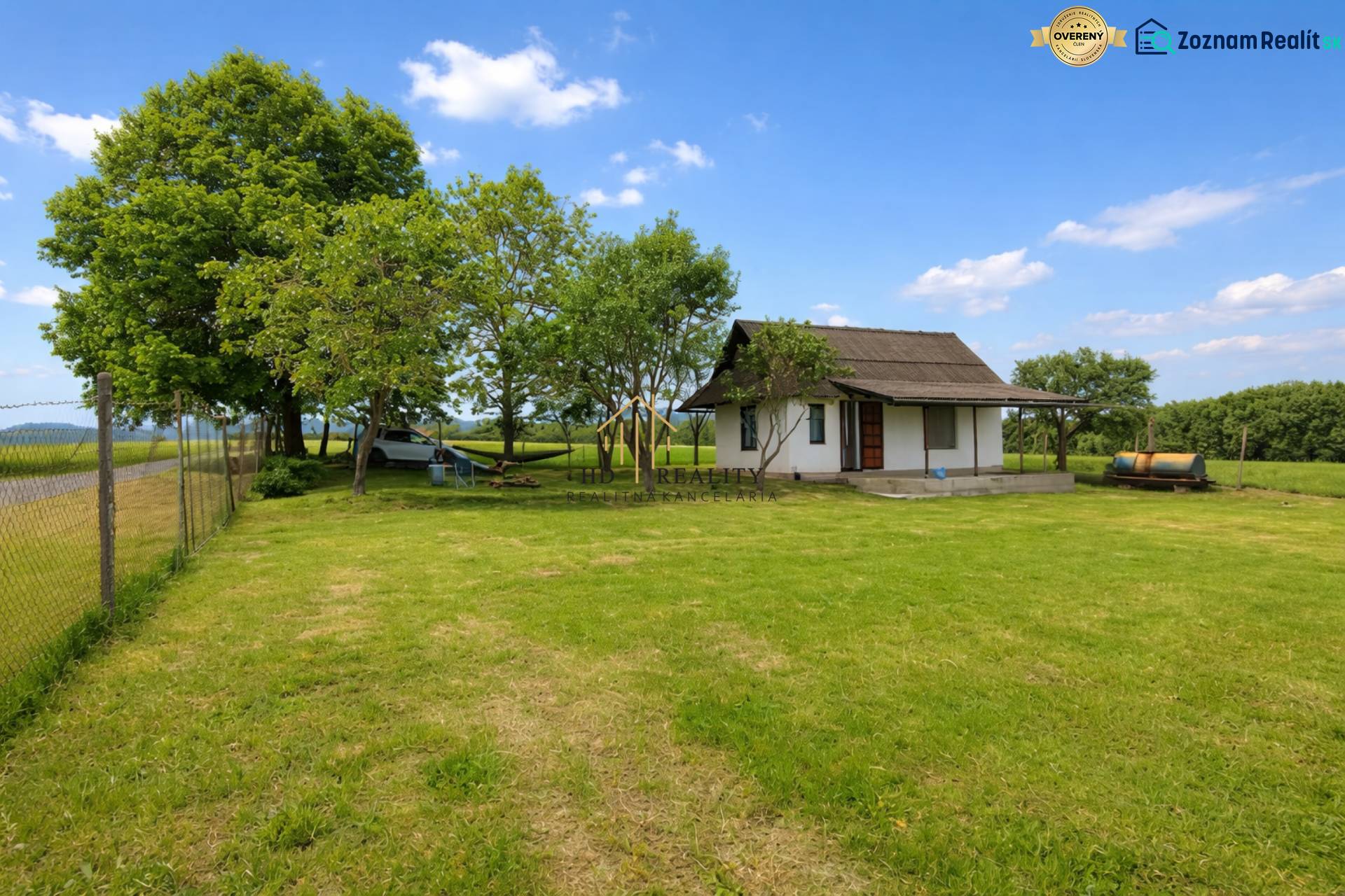 Chata v Obeckově obklopená přírodou s udržovaným trávníkem a dřevinami.