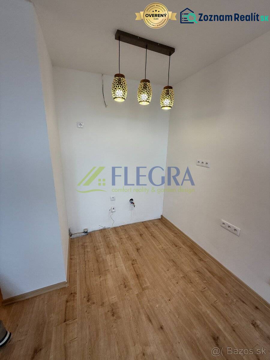 Interiér 1-pokojového bytu s podlahou s dřevěným dekorem a závěsnými svítidly.