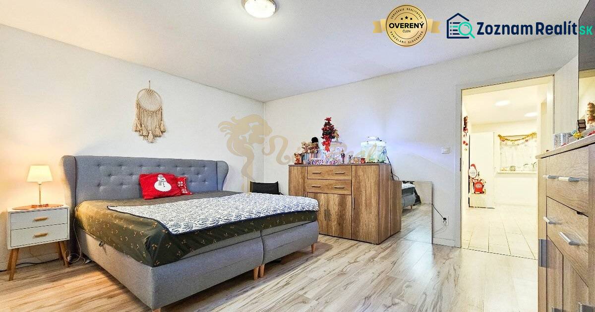 Ložnice v rodinném domě s podlahou s dřevěným dekorem a vánočními dekoracemi.