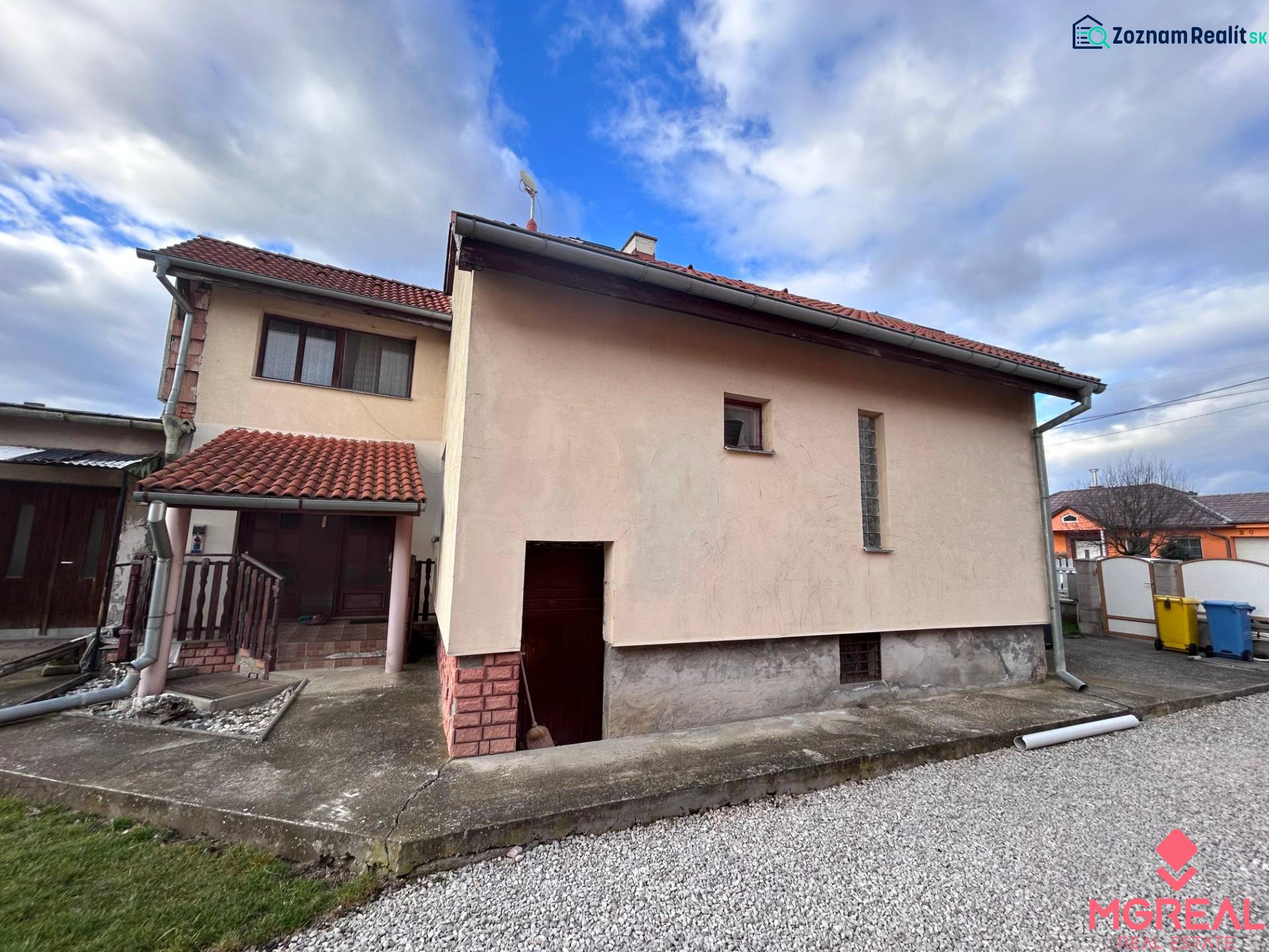 Rodinný dům v Zbehoch se šikmou střechou a chodníkem vedle garáže.