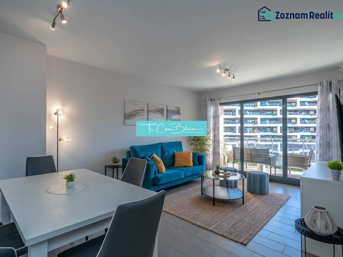 Obývací pokoj v 2pokojovém bytě s podlahou s dřevěným dekorem a posezením.