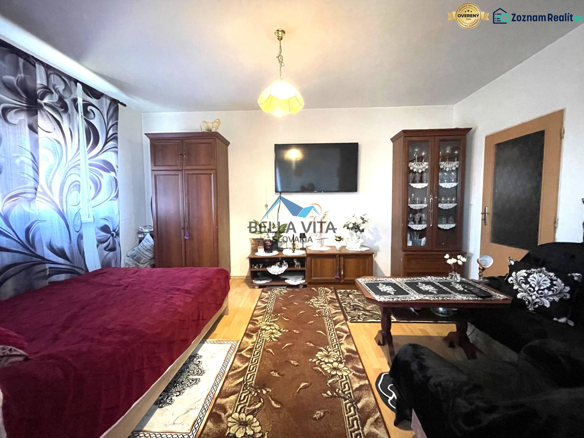 Obývací pokoj v jednopokojovém bytě s podlahou s dřevěným dekorem a nábytkem.