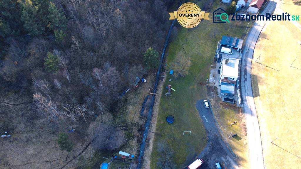 Letecký pohled na Rekreační pozemky Župkova s budovami, stromy a cestou.