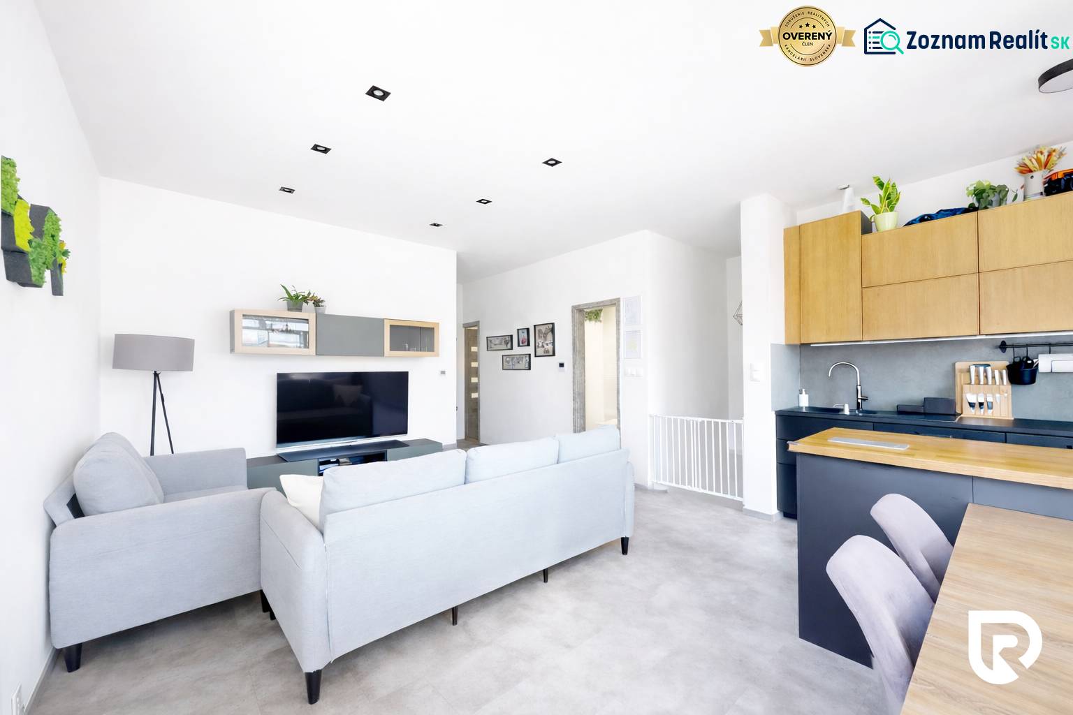 Světlý obývací pokoj ve 3-pokojovém bytě s pohodlnou pohovkou a televizí.