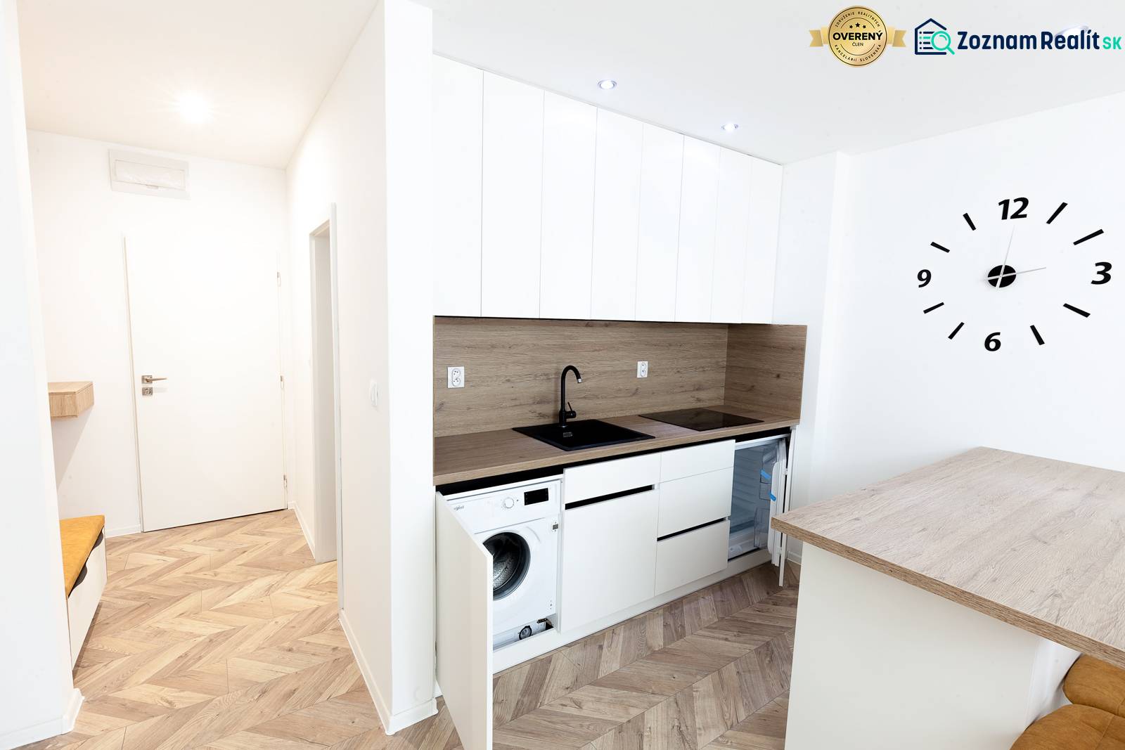 Moderně zařízená kuchyně s podlahou s dřevěným dekorem v rekreačním apartmánu.