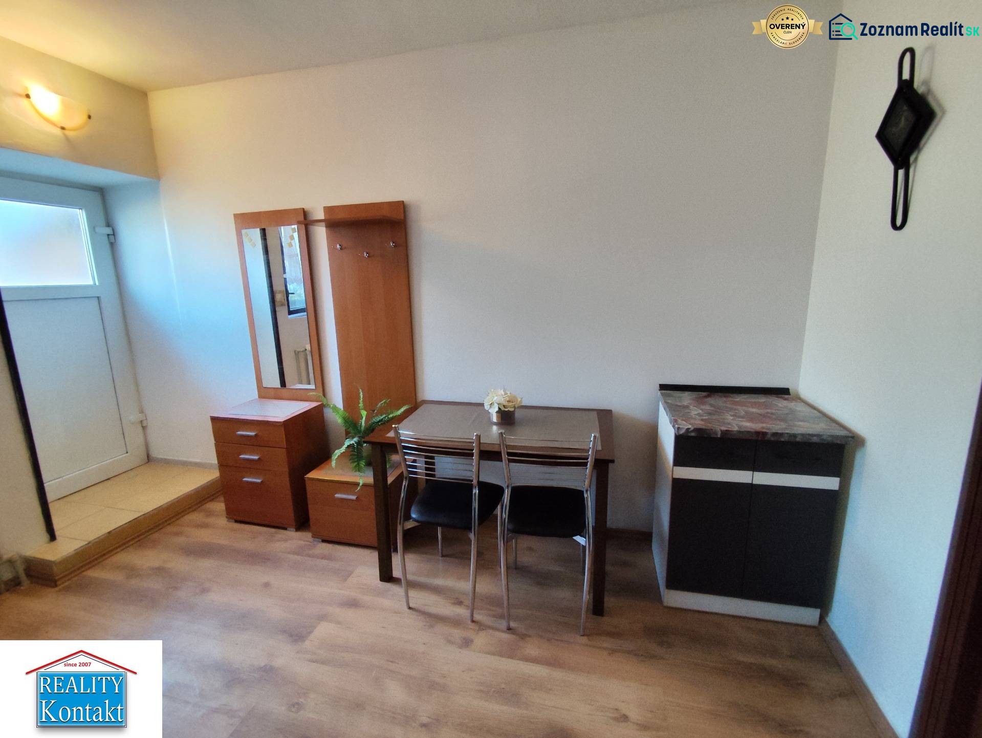 Interiér 1-pokojového bytu s nábytkem a podlahou s dřevěným dekorem.