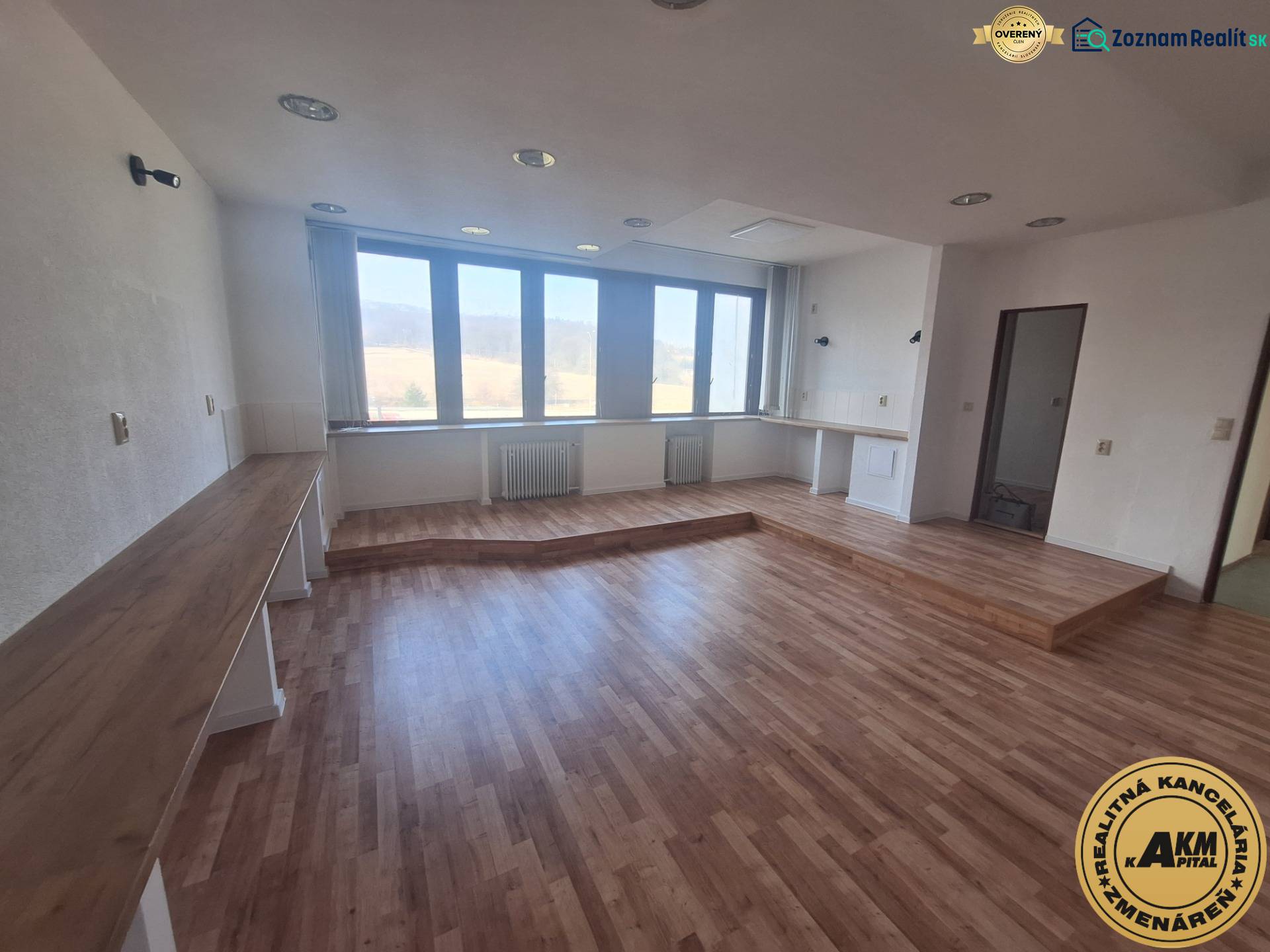 Obchodní prostory s podlahou s dřevěným dekorem a velkými okny.