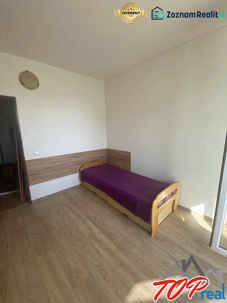Ložnice se světlým nábytkem, jednolůžkem a podlahou s dřevěným dekorem ve 4-pokojovém bytě.