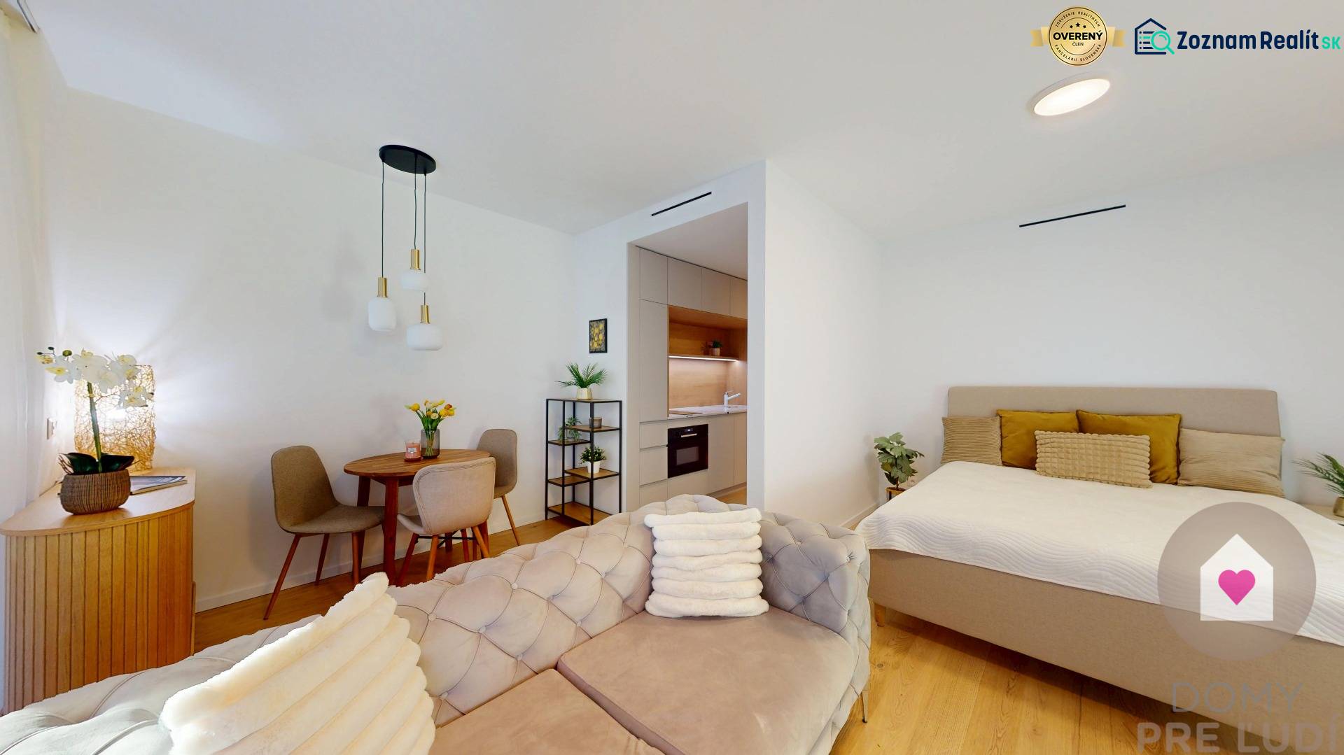 1-pokojový byt se sedací soupravou, jídelním stolem, kuchyní a postelí, podlaha s dřevěným dekorem.