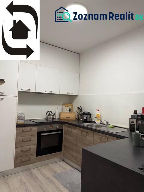 Kuchyně v 2-pokojovém bytě s podlahou s dřevěným dekorem a bílými skříňkami.
