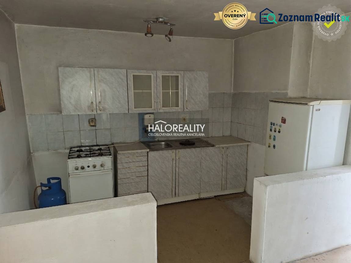 Kuchyňská linka s plynovým sporákem a lednicí v interiéru. Pozemky - bydlení.