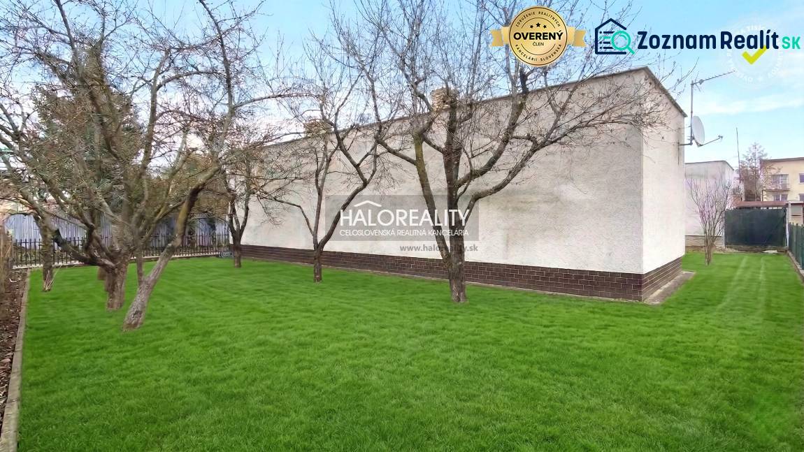 Zahrada s trávníkem a stromy u rodinného domu v Poltáři.