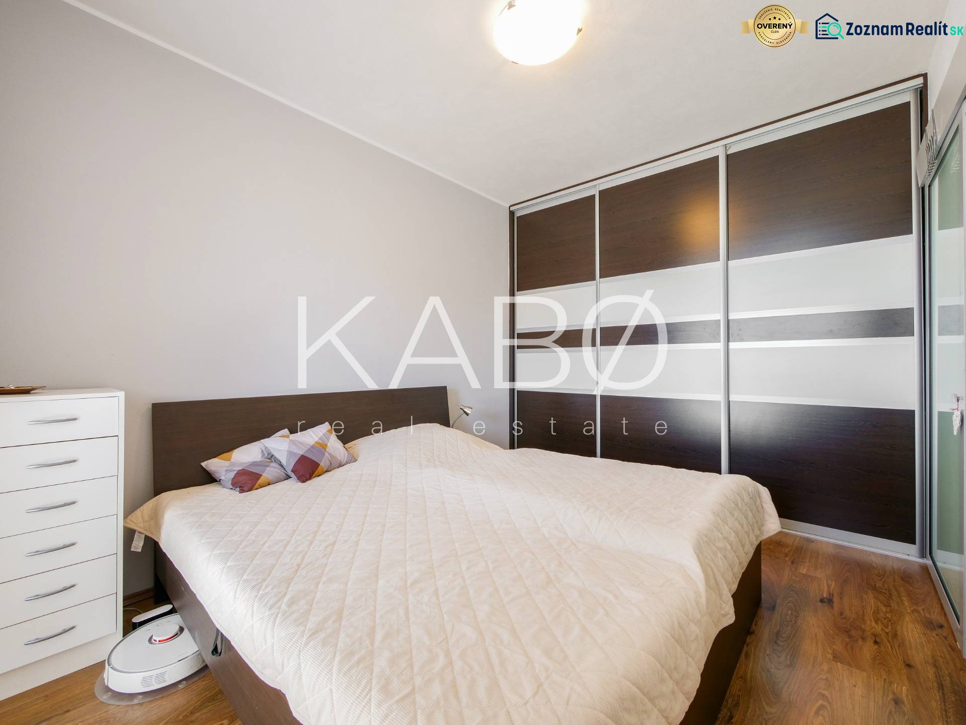 Ložnice v 3-pokojovém bytě s podlahou s dřevěným dekorem a vestavěnou skříní.