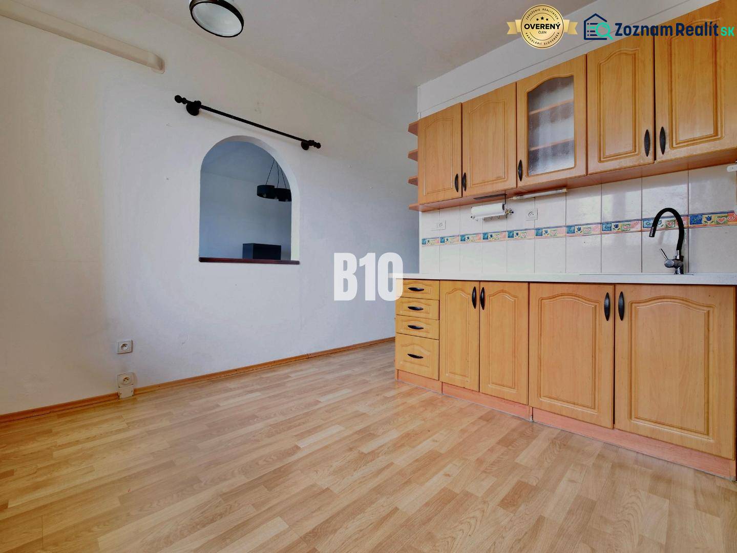 Kuchyně ve 3-pokojovém bytě s podlahou s dřevěným dekorem a vestavěnými skříňkami.
