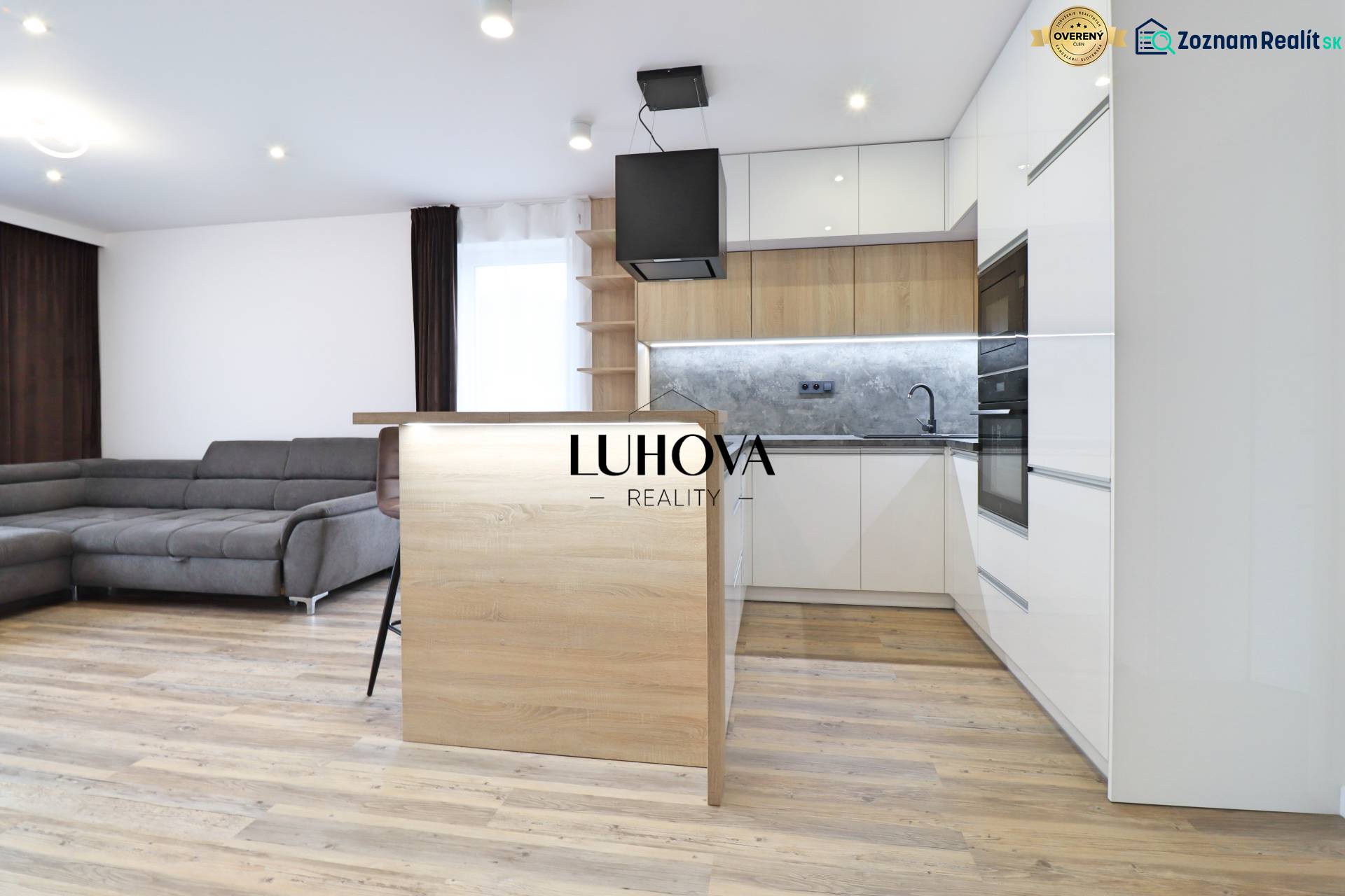 Obývací pokoj s kuchyní a podlahou s dřevěným dekorem ve 3pokojovém bytě.