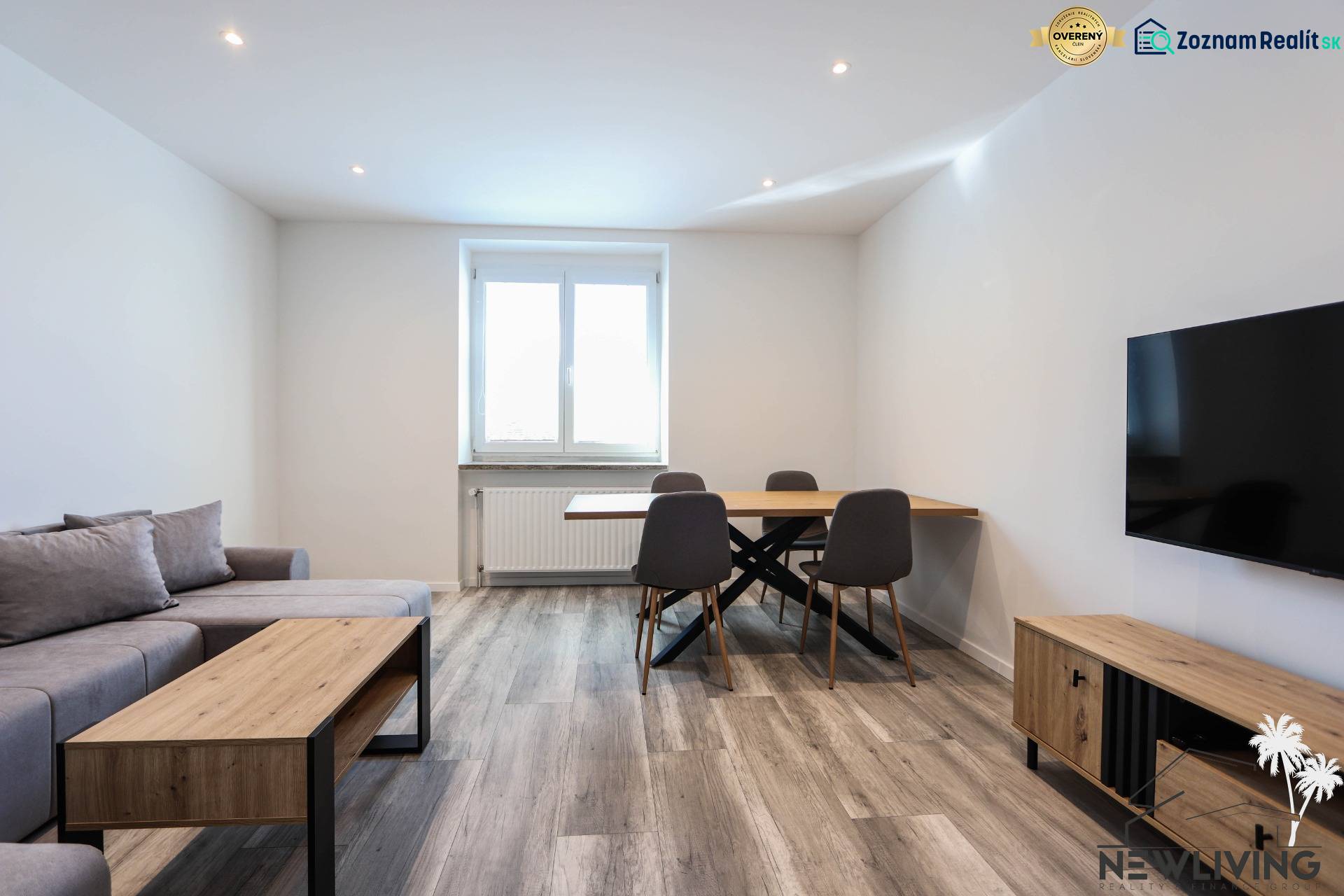 Obývací pokoj s podlahou s dřevěným dekorem, sedačkou, jídelním stolem a televizí ve 3-pokojovém bytě.
