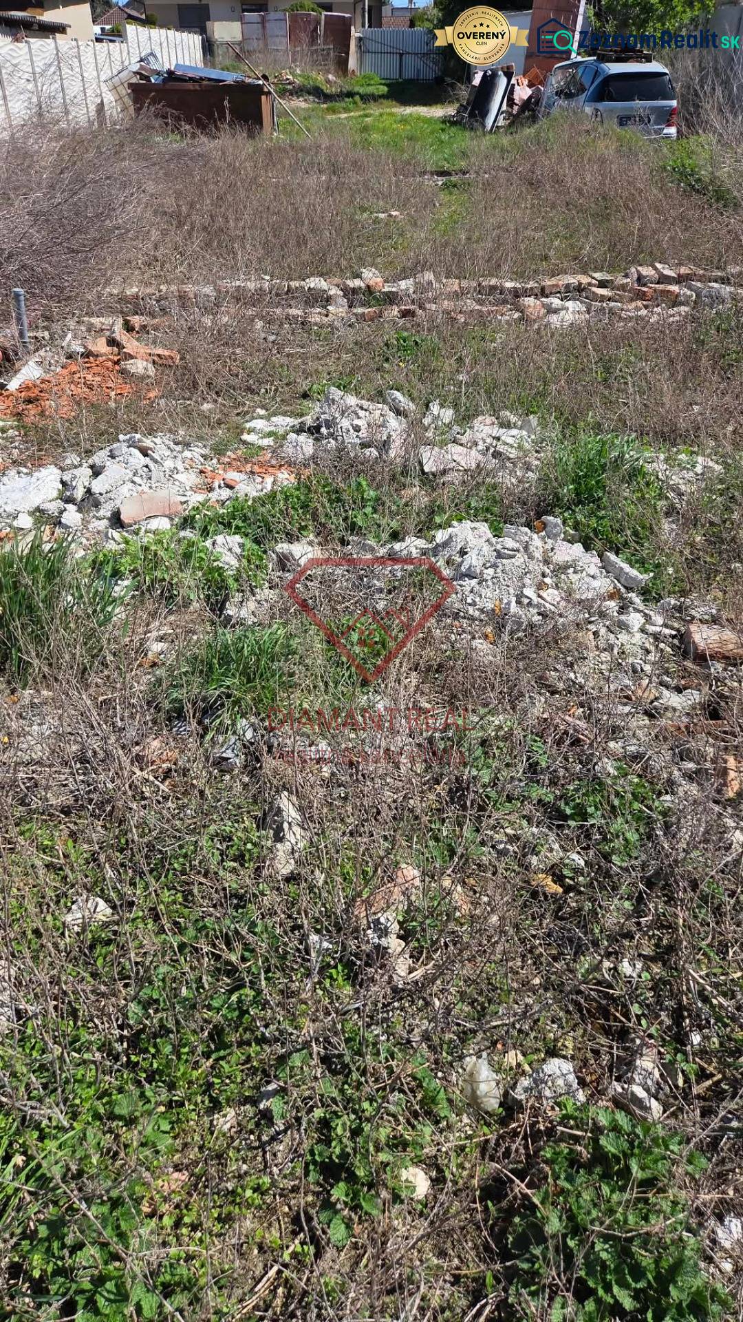Pozemek na bydlení v Tešedíkově na ulici Tešedíkovo s neudržovanou vegetací a stavebním odpadem.