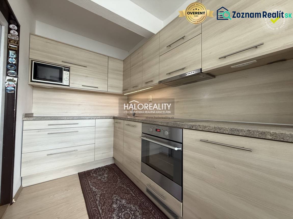 Kuchyně v rodinném domě s linkou a podlahou s dřevěným dekorem.