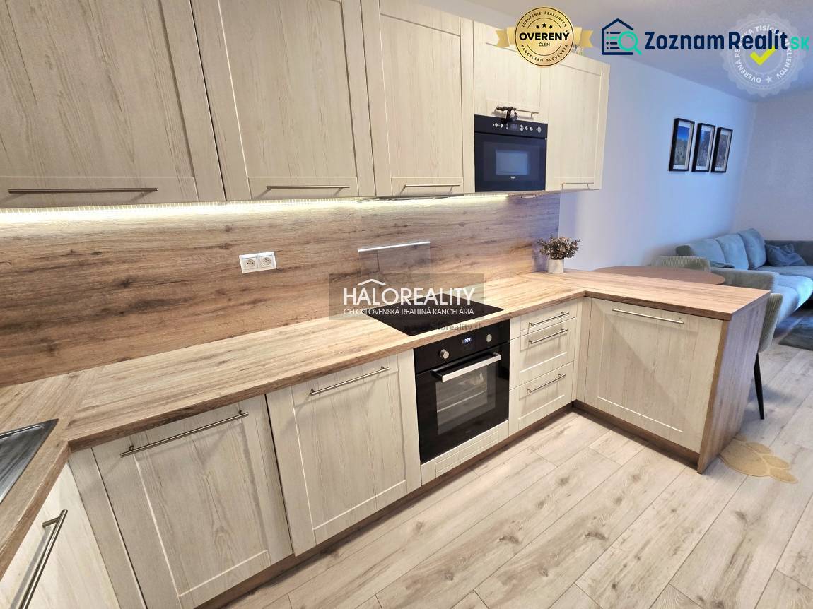 Kuchyně s podlahou s dřevěným dekorem v 2-pokojovém bytě, světlé dřevěné skříňky a vestavěné spotřebiče.