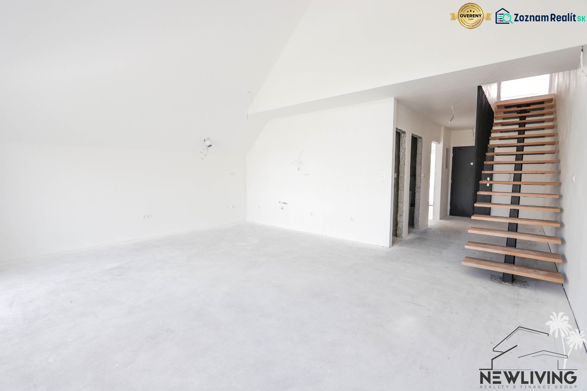 Interiér 4-pokojového bytu s betonovou podlahou a dřevěným schodištěm.