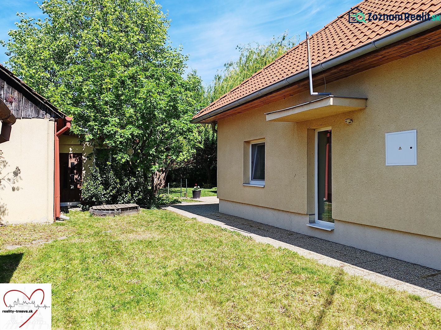 Rodinný dům na Devátově ulici ve Sládkovičově s trávníkem a stromy.