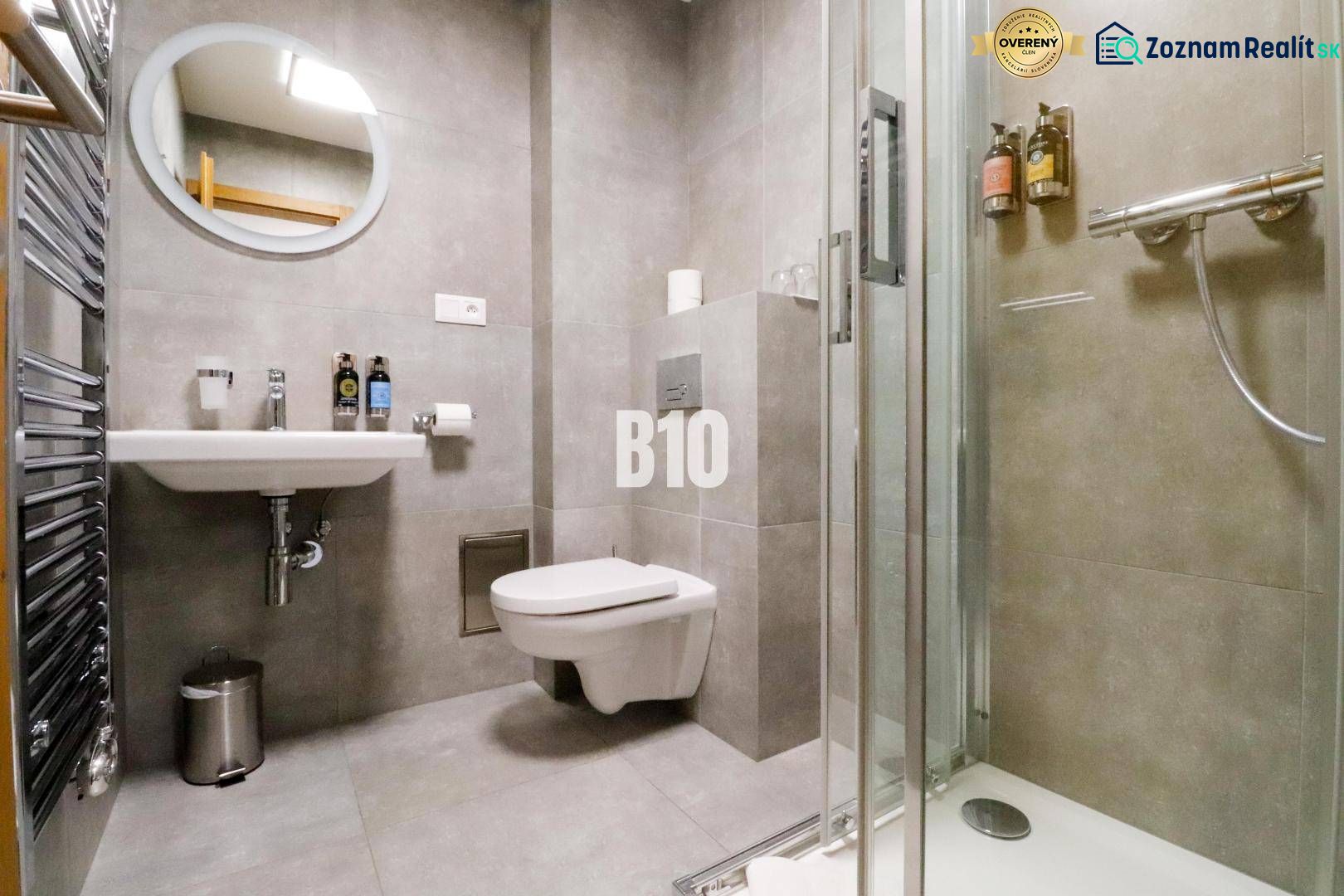 Koupelna rekreačního apartmánu se sprchovým koutem, toaletou a umyvadlem v elegantním designu.