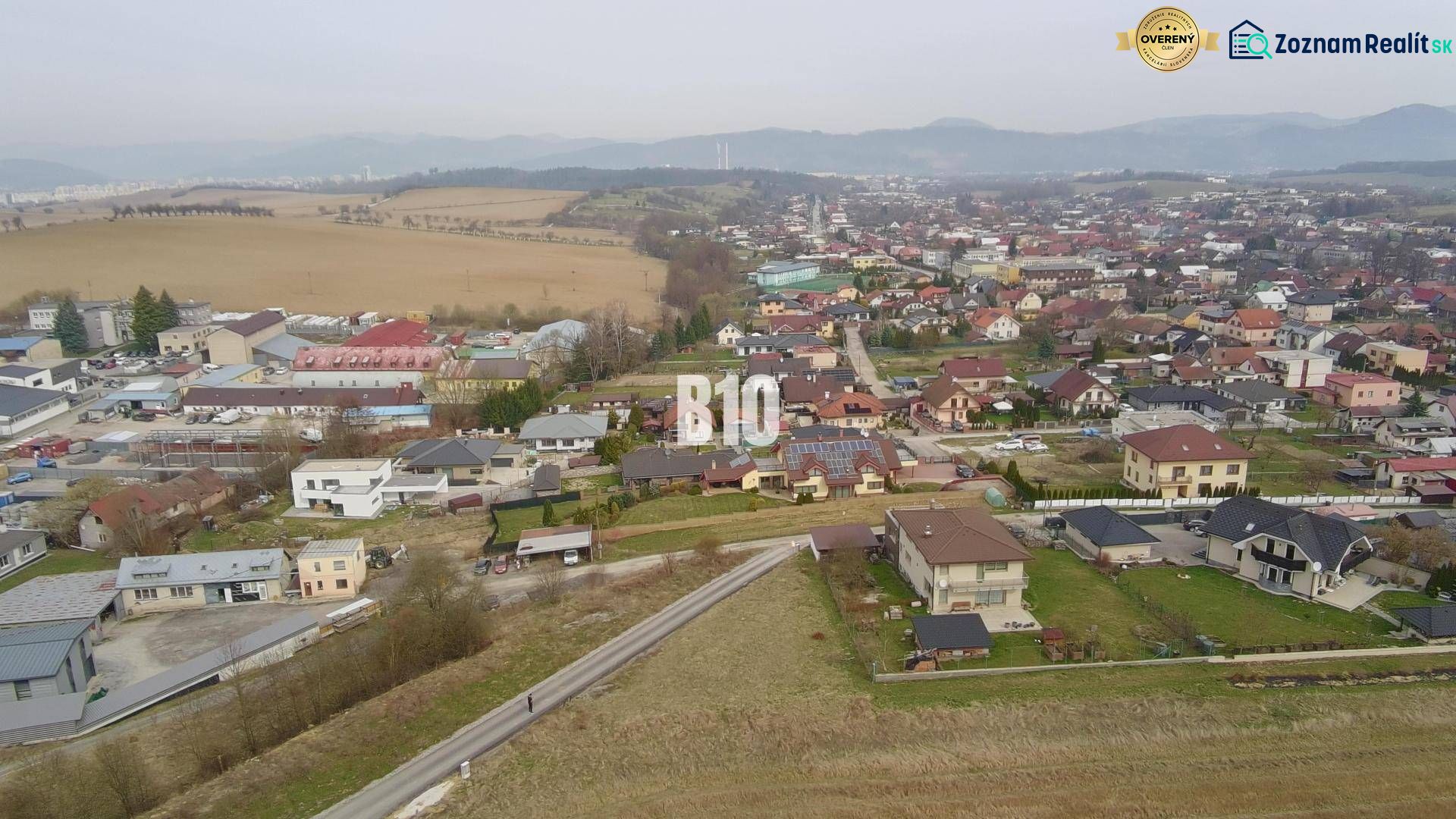 Letecký pohled na obytnou oblast v Rosině s domy a zelení. Pozemky - bydlení.