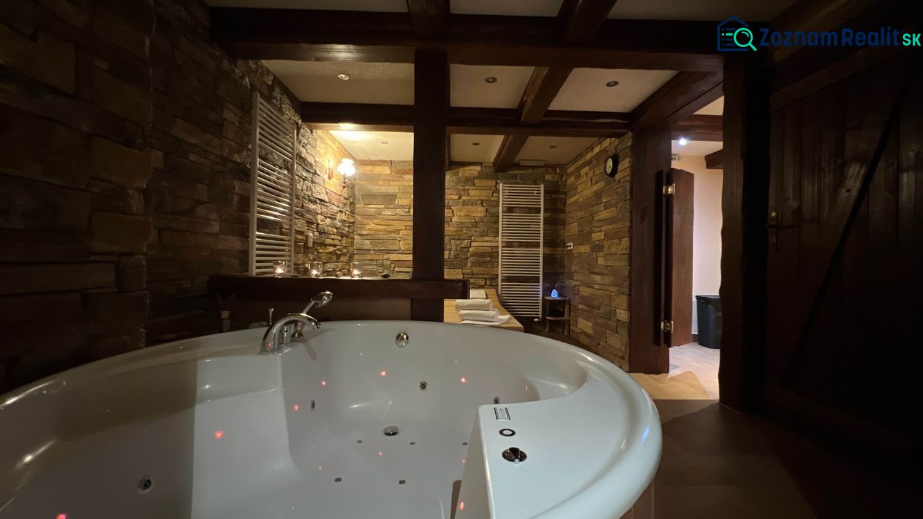 Relaxační místnost s vanou a kamennými stěnami v hotelu a penzionech.