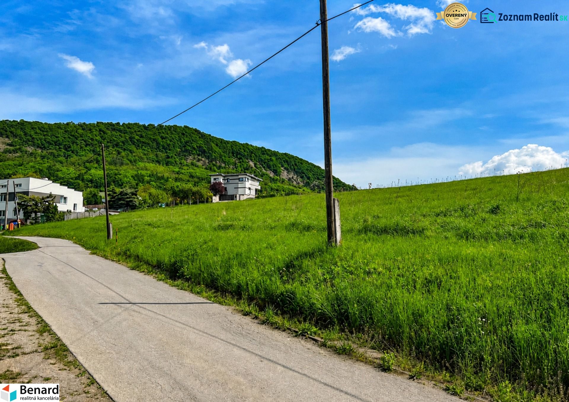 Kopcovitá krajina u Fintic s pozemky na bydlení a venkovem v pozadí.