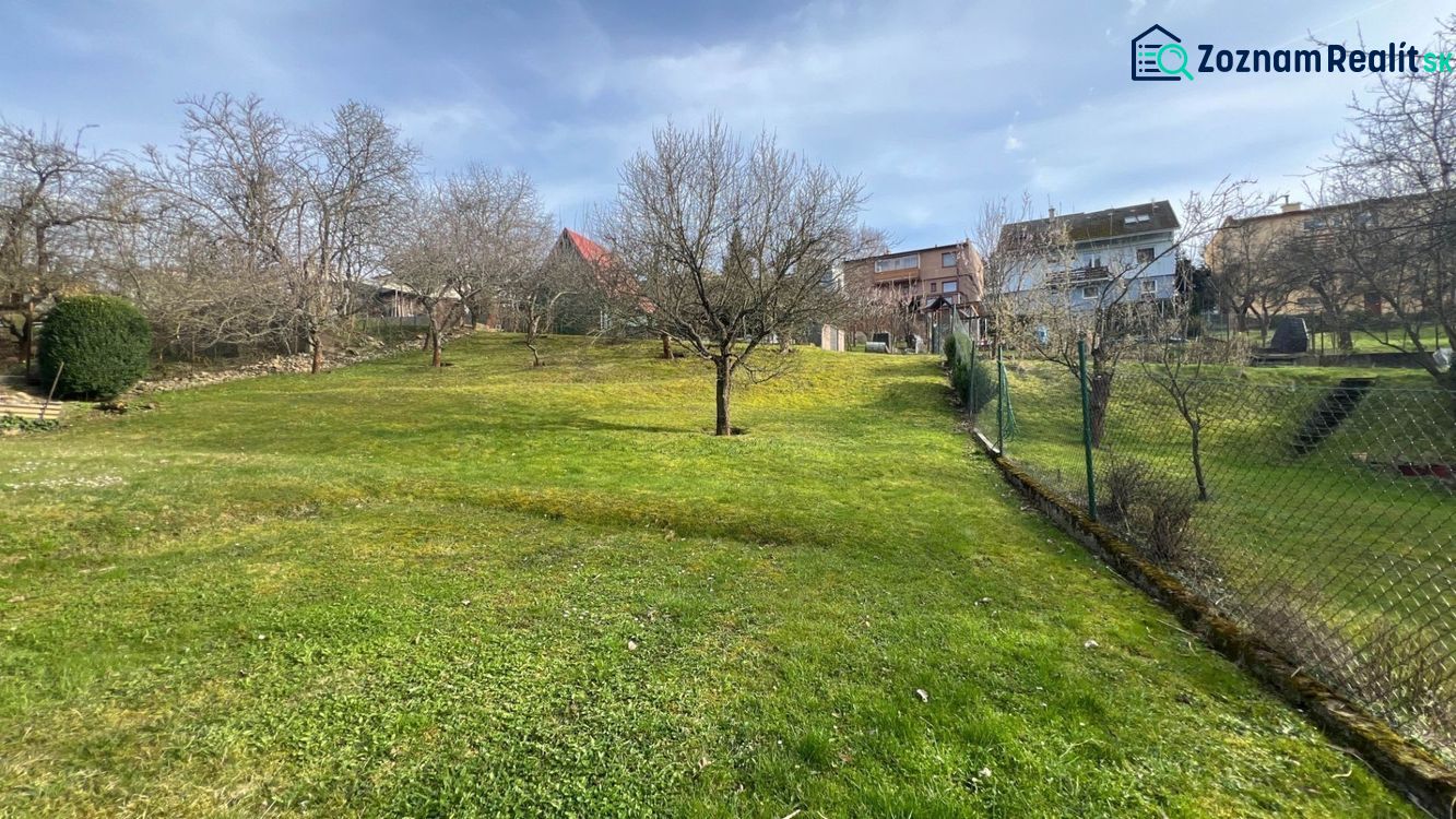 Zahrada rodinného domu na ulici Makovického v Ružomberku se stromy a trávníkem.