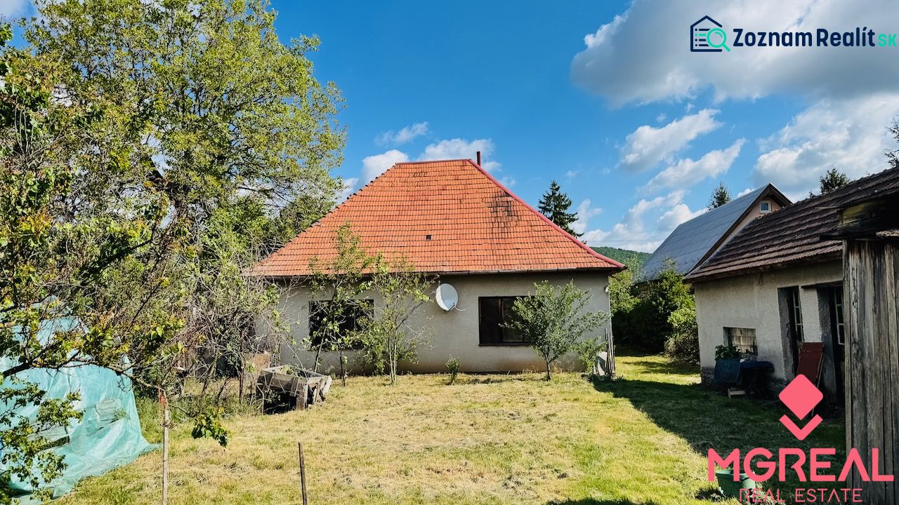 Rodinný dům v Pažiti s červenou střechou na upravené zahradě.