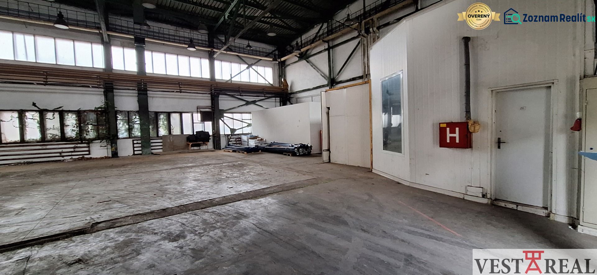Interiéry skladů a hal se staršími dveřmi a prosklenými okny, industriální prostor.