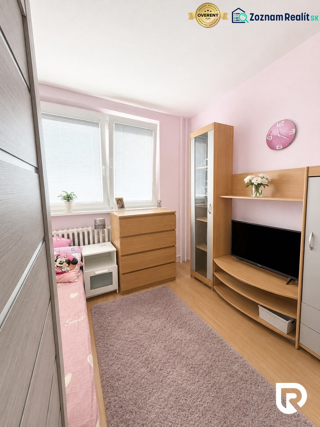Dětský pokoj s podlahou s dřevěným dekorem, růžovými stěnami a dřevěným nábytkem ve 3-pokojovém bytě.