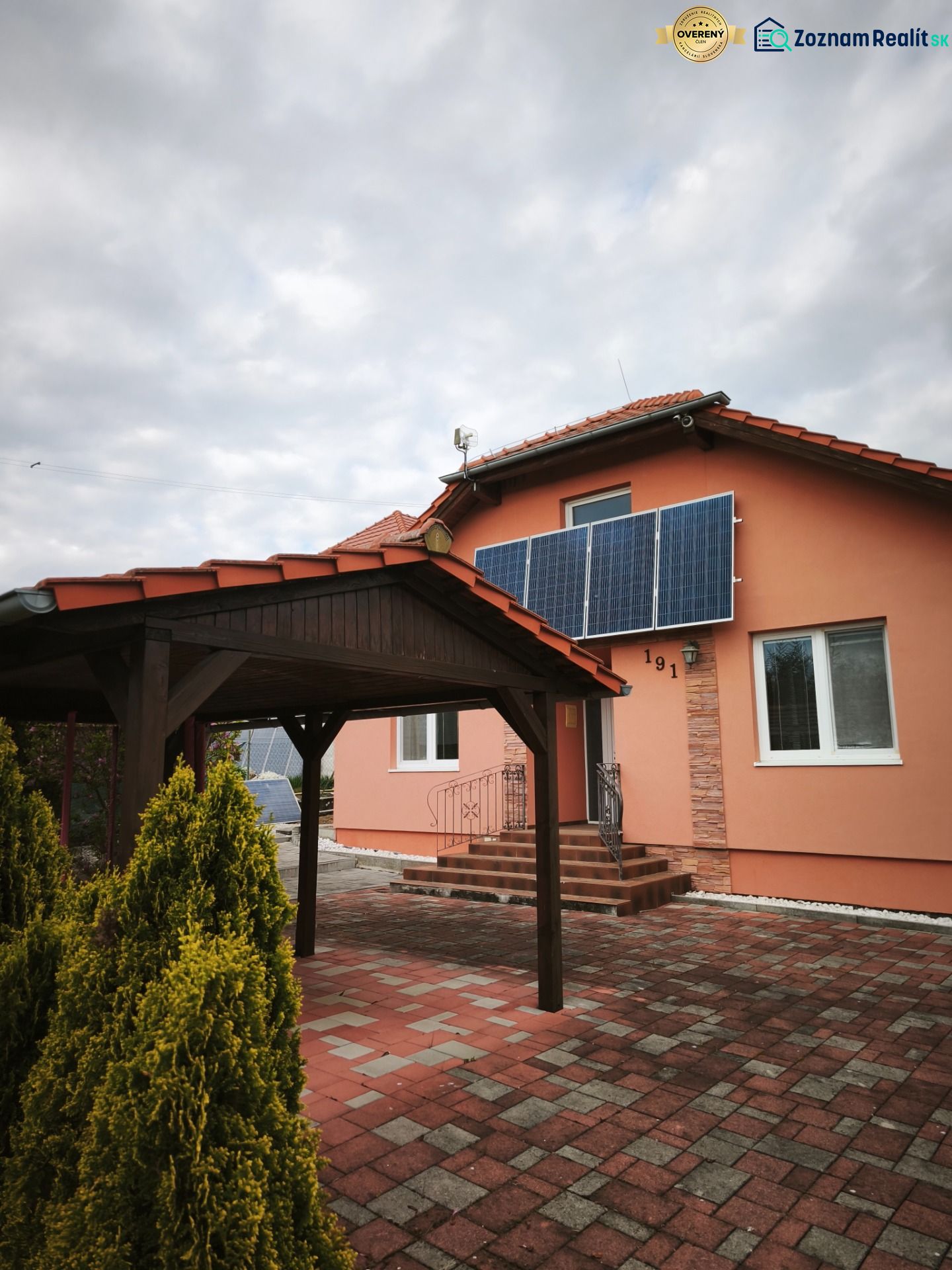 Rodinný dům v Martin nad Žitavou se solárními panely a altánem na terase.