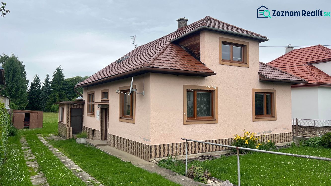 Rodinný dům v Ľubeli s červenou střechou, trávníkovým dvorem a venkovním skladem.