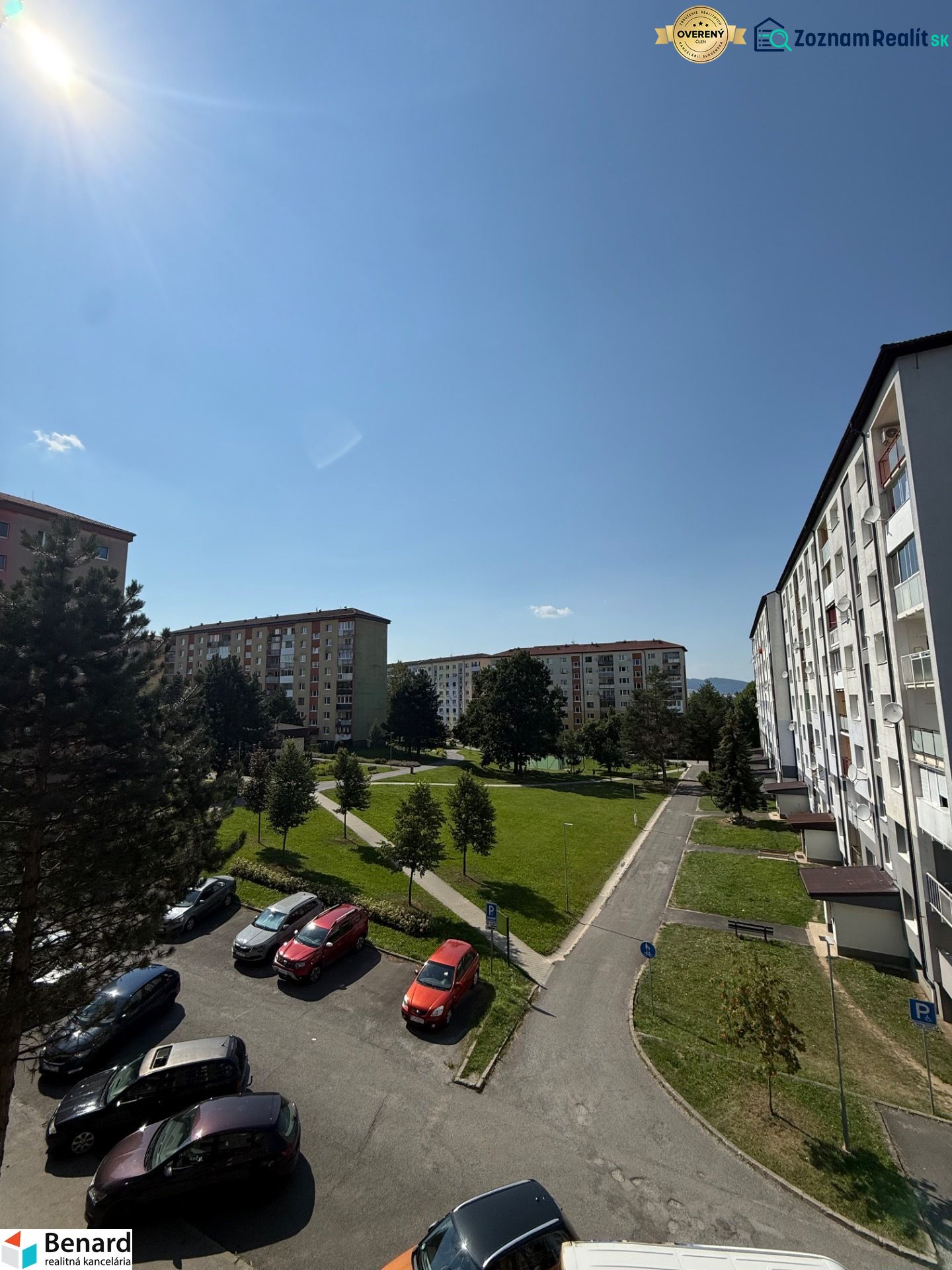 Pohled na sídliště s parkovištěm, stromy a bytovými domy na Mírové ulici ve Staré Ľubovni.