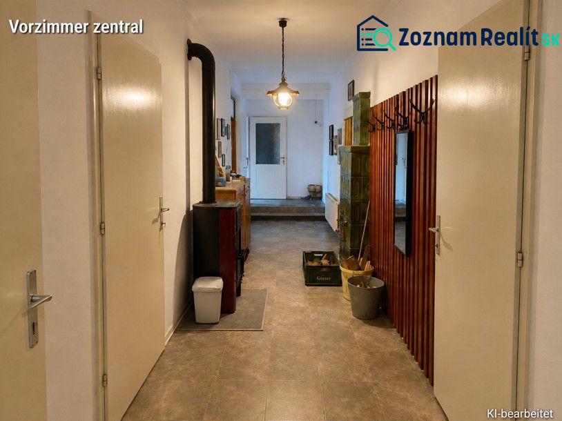 Chodba v rodinném domě s věšákem, zrcadlem a pecí, podlaha s dřevěným dekorem.