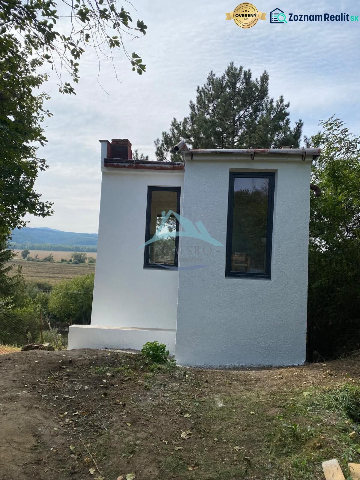 Malá chata v Šahách, obklopená stromy a krásnou přírodou.