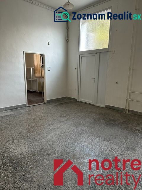 Interiér kanceláře s bílými stěnami a podlahou v dekoru betonového efektu.