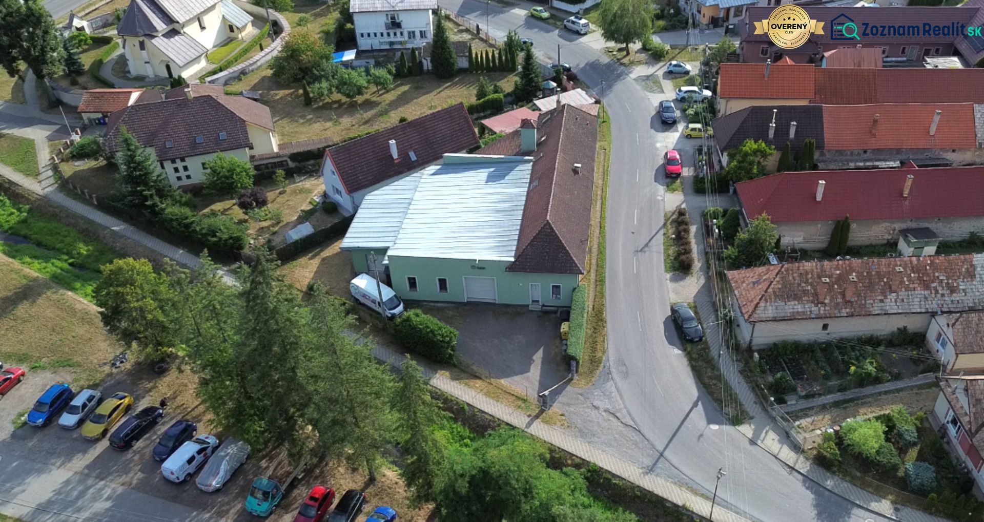 Letecký pohled na výrobní prostory v Budči obklopené domy a zelení.
