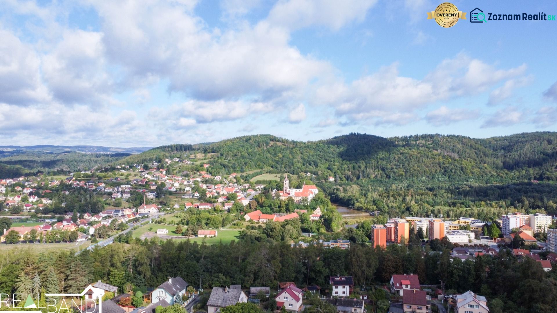 Pohled na město Sázava z ulice Na Vrších, obklopené zelení a rodinnými domy.