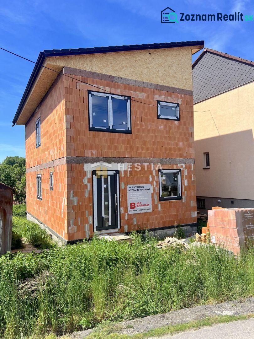 Nedokončený rodinný dům v Cerové s viditelnými cihlovými stěnami a plastovými okny.