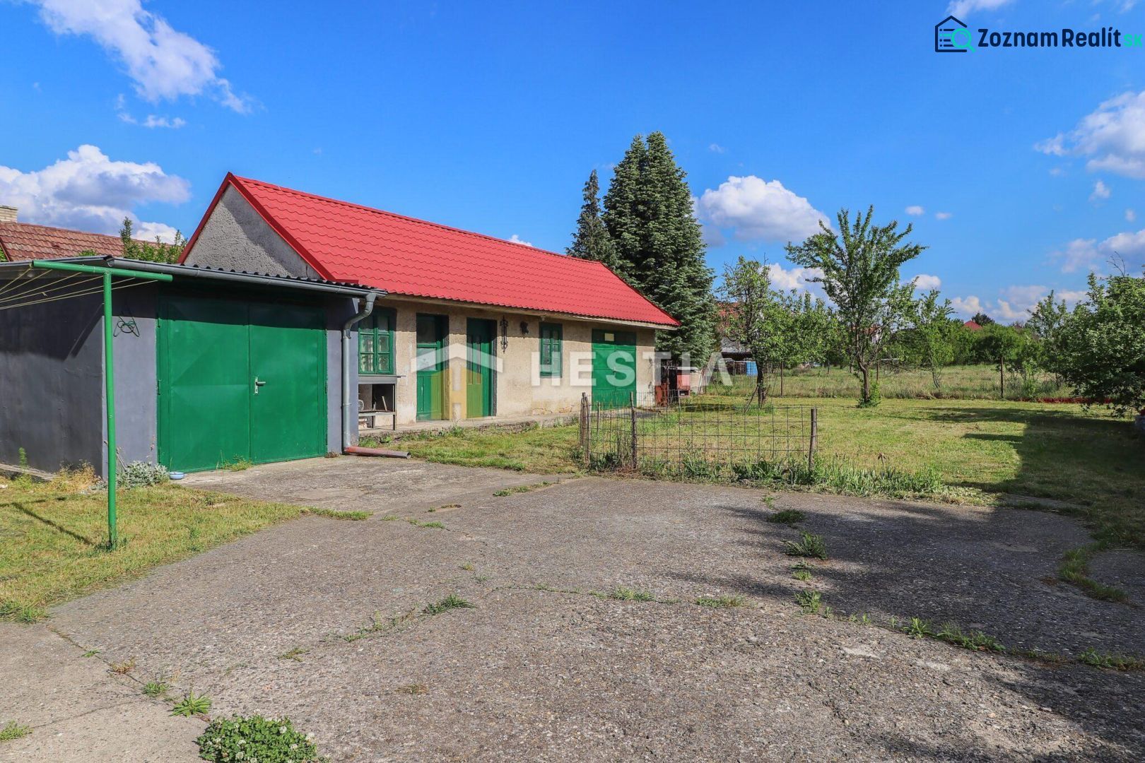 Rodinný dům v Borském Mikuláši s travnatou zahradou a červenou střechou.