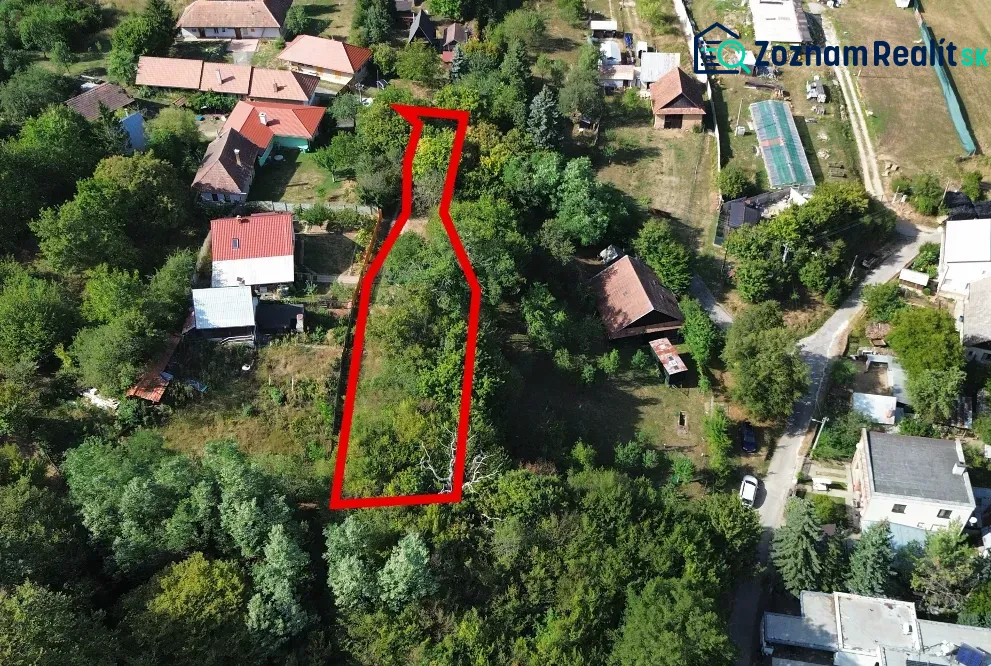 Letecký pohled na zahrady v Kolačne obklopené domy a zelení.