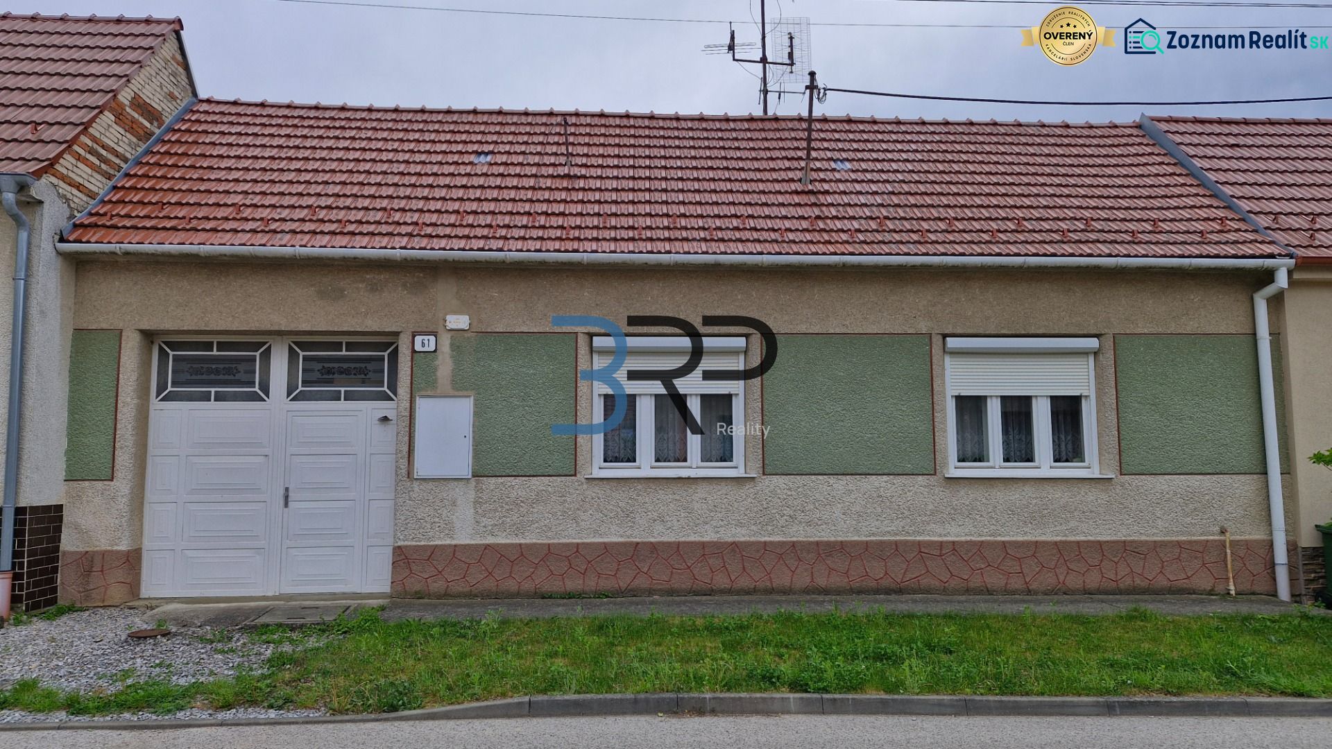 Rodinný dům v Mokrém Háji s červenou střechou a garážovými dveřmi.