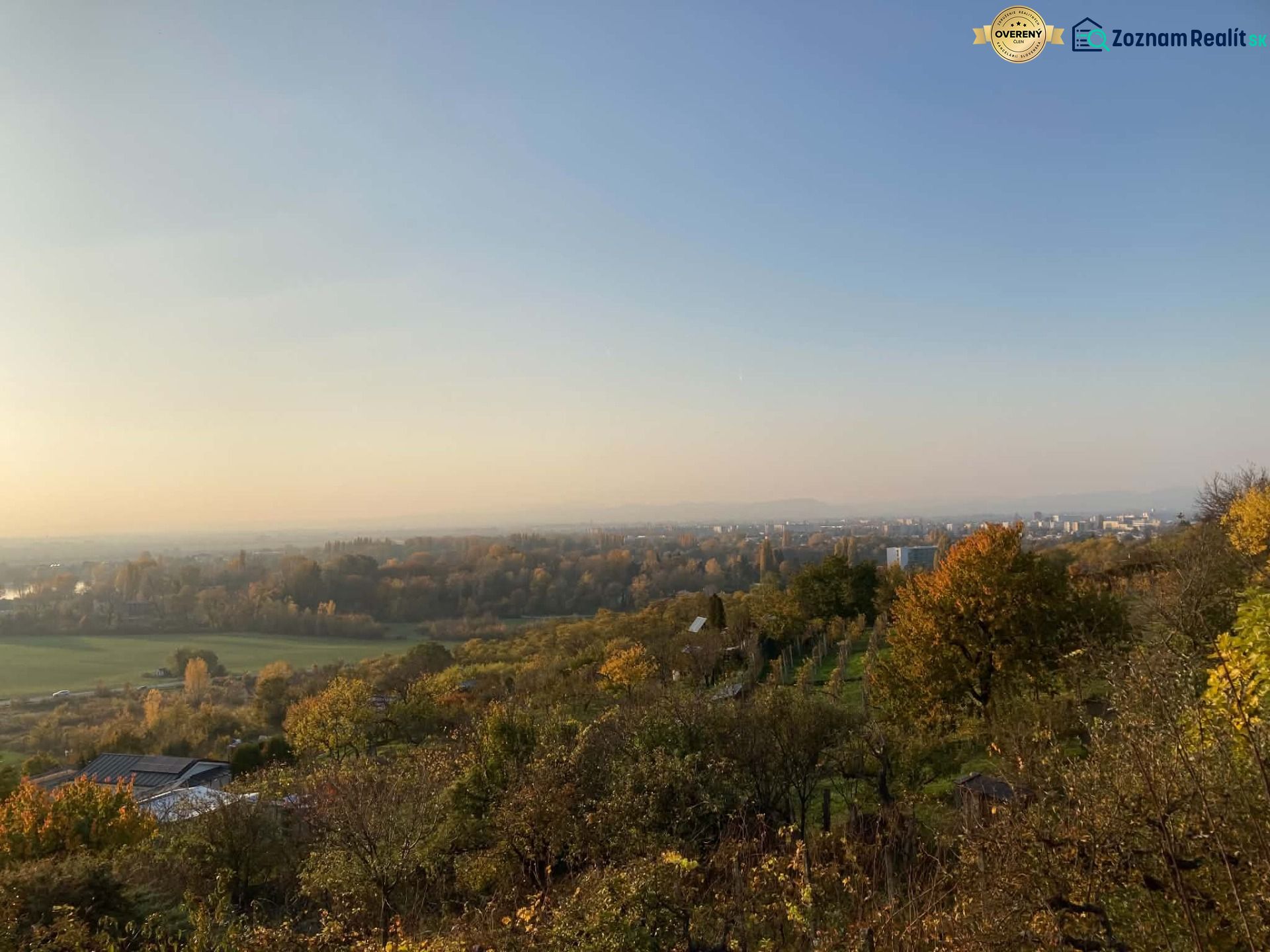 Panoráma podzimního lesa a polí s výhledem na město Banka.