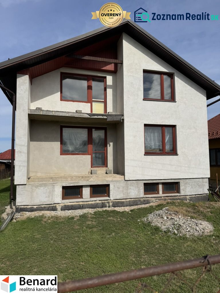 Rodinný dům v Plavnici s jednoduchou fasádou a novými okny, s travnatým pozemkem.
